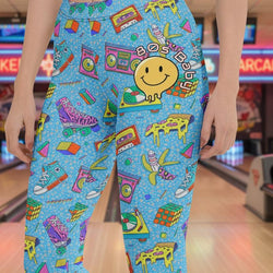 80s Baby retro leggings with smiley face, cassette tapes, roller skates, and Rubik’s cubes on blue background
