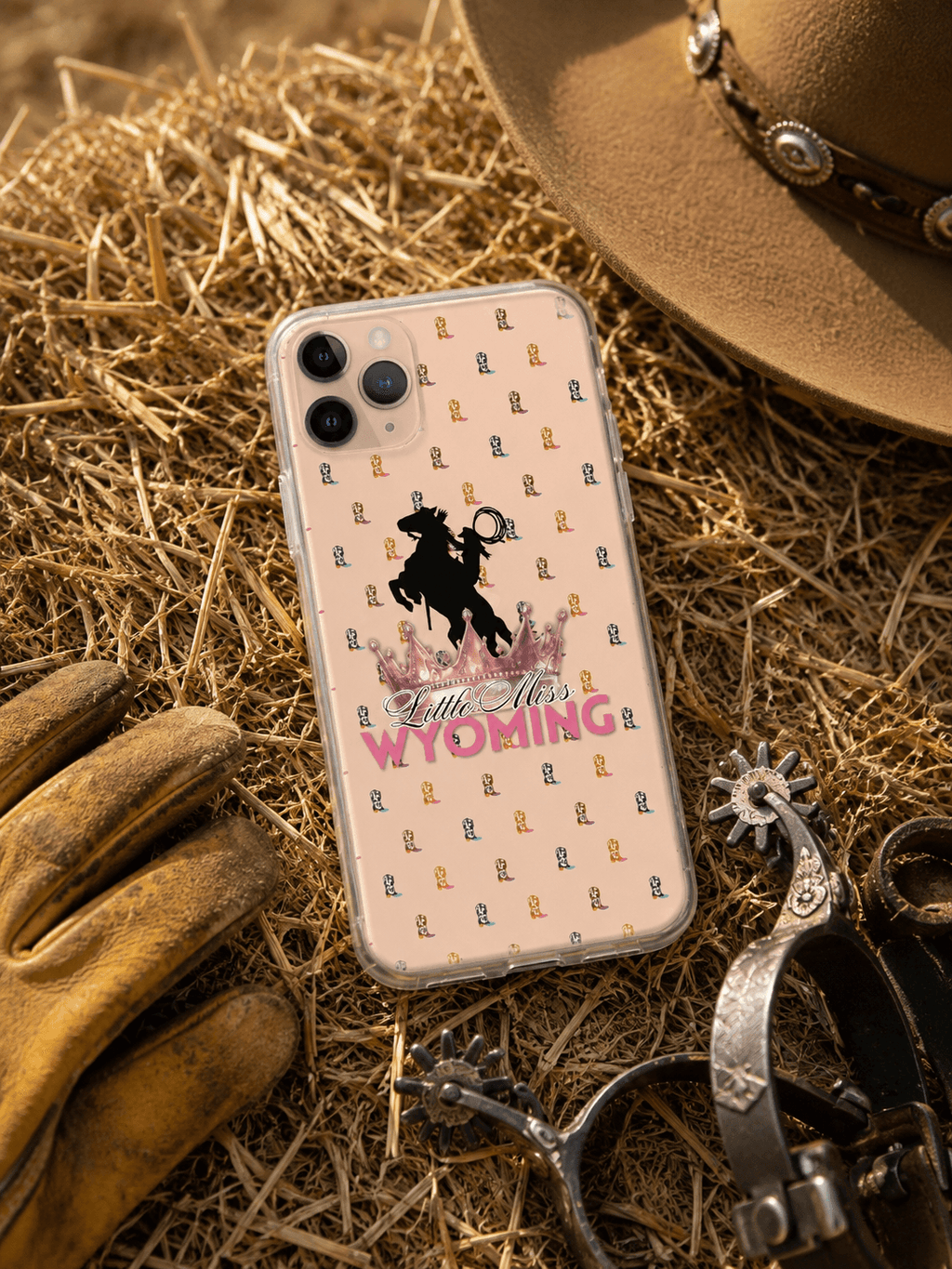 Little Miss Wyoming phone case with cowboy boots pattern, rodeo crown, and horse silhouette on hay with cowboy hat and spurs