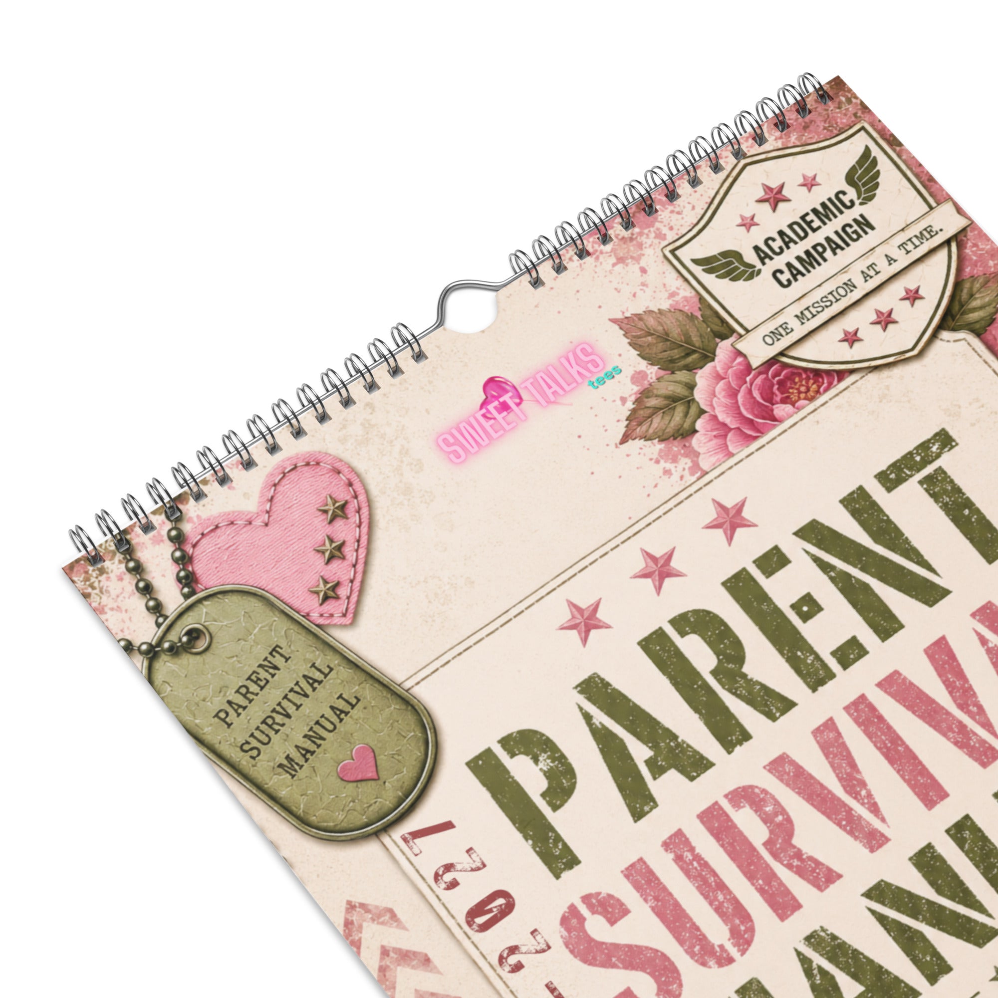 A spiral-bound calendar cover with a distressed vintage design, featuring the words 'PARENT SURVIVING' in large green and pink letters, pink roses, stars, and hanging dog-tag style decorations reading 'PARENT SURVIVAL MANUAL' and 'ACADEMIC CAMPAIGN'.