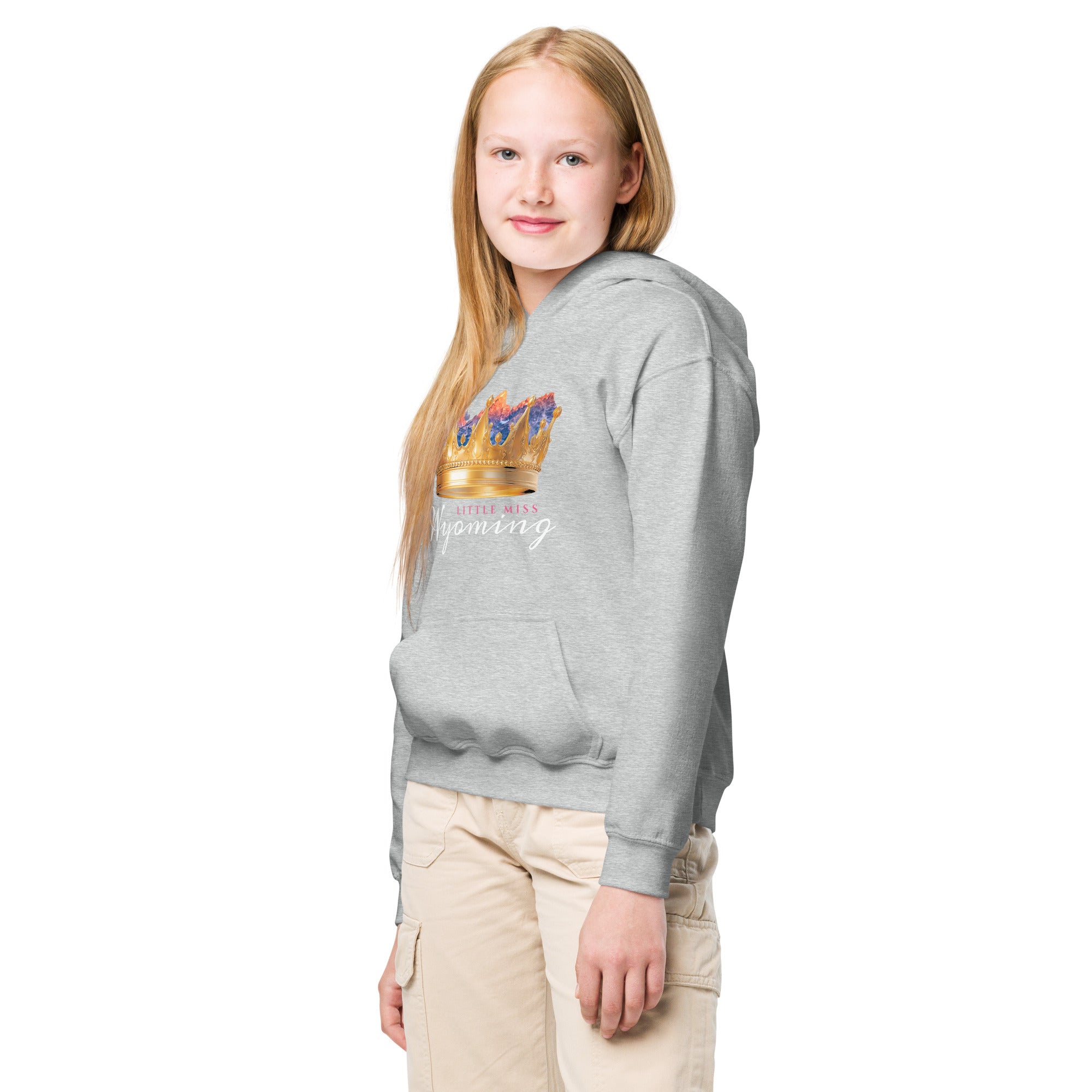 Young girl wearing a gray hoodie with a design on the chest against a white background